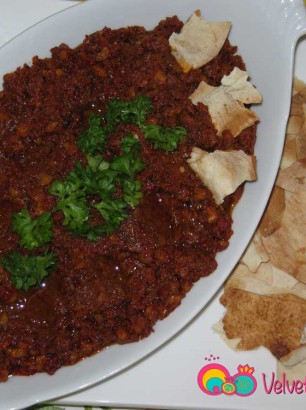 Plate the muhammarah and sprinkle some olive oil and garnish with parsley.