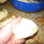 Hold the pastry in one hand and place the cheese filling inside with the other hand.