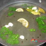 Add the water, lemon slices, bay leaves and parsley, peppercorns, wine and garlic cloves. Bring water to a boil.