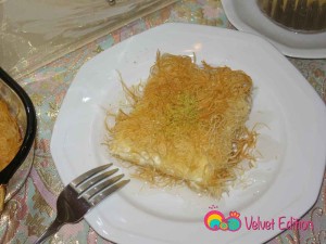Garnish the kataifi with chopped pistachios and drizzle the syrup over. Serve warm.