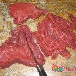 Trim the steaks by removing the fat and cutting the meat across the grain.