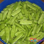 Cut the tip off both ends of the beans, then snap each bean lengthwise in half. Place in a bowl of water and rinse twice.