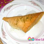 Shaabiyat served warm with syrup and ground pistachios.