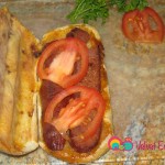 After the soujouk is grilled open it up and add the slices of tomatoes and pickles.