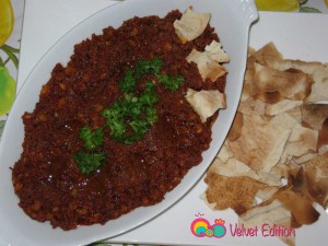 Plate the muhammarah and sprinkle some olive oil and garnish with parsley.