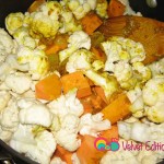 Add the cauliflower and sweet potato to the onions and spices.