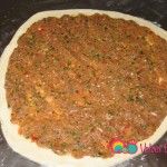 Add the meat mixture and pat down with your hands evenly all over the dough, leaving about a ¼ inch around the border.