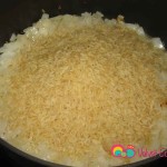 Add the rice to the cooked onions.